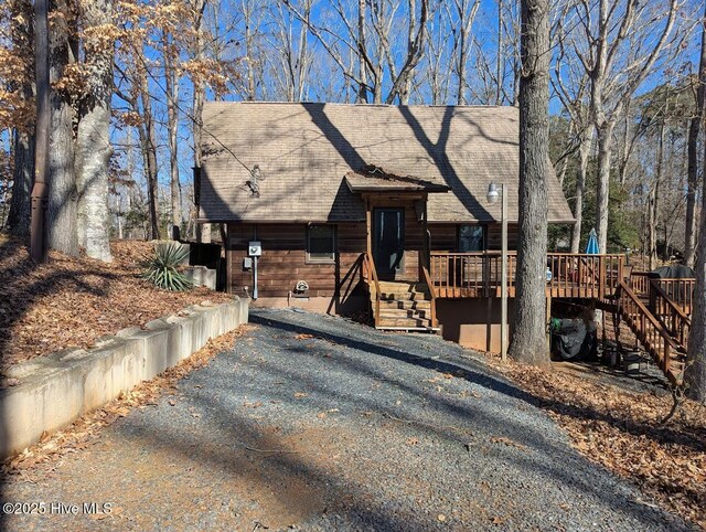 view of front of house featuring a deck and a shingled roof