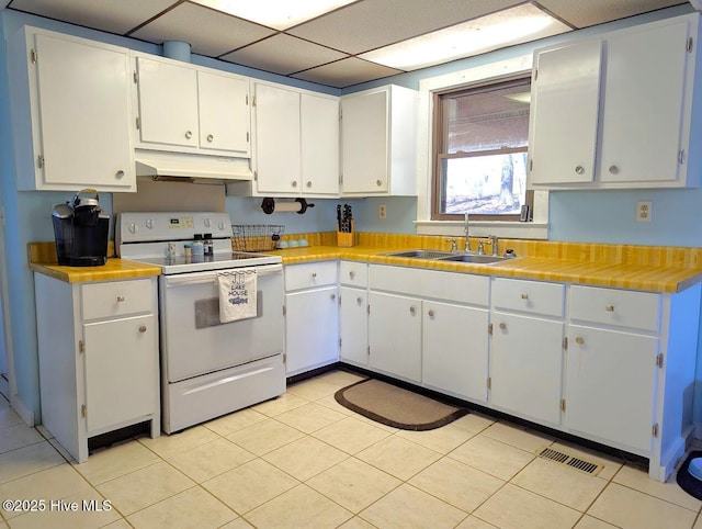 kitchen featuring under cabinet range hood, a drop ceiling, light countertops, white electric range oven, and a sink