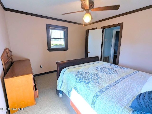 carpeted bedroom featuring ceiling fan, visible vents, baseboards, and ornamental molding