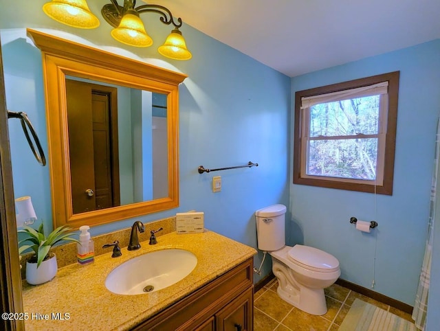bathroom featuring tile patterned flooring, toilet, vanity, and baseboards