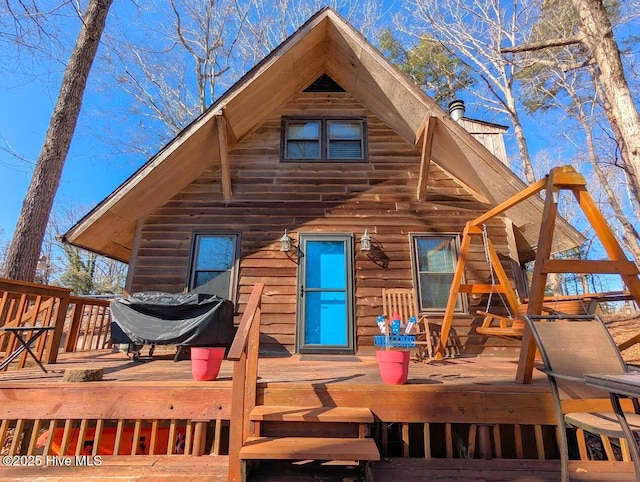 rear view of property featuring a wooden deck