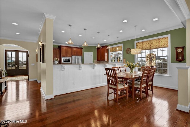 42 Harbour Village Ter, Hampstead, NC 28443 - dining area with arched walkways, crown molding, baseboards, and dark wood-style flooring