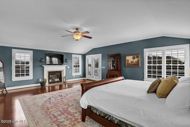42 Harbour Village Ter, Hampstead, NC 28443 - bedroom with a glass covered fireplace, baseboards, wood finished floors, and vaulted ceiling