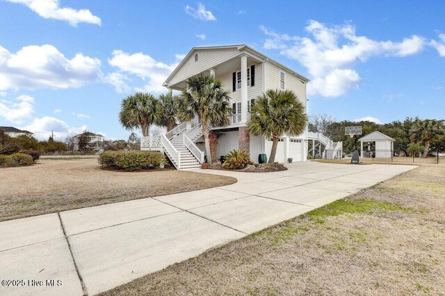 42 Harbour Village Ter, Hampstead, NC 28443 - beach home featuring a porch, concrete driveway, stairs, and a garage