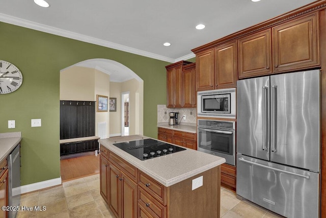 42 Harbour Village Ter, Hampstead, NC 28443 - kitchen with arched walkways, decorative backsplash, light countertops, appliances with stainless steel finishes, and a center island