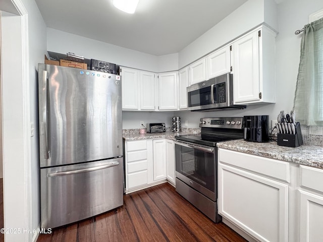 310 Wimbledon Ct, Wilmington, NC 28412 - kitchen with appliances with stainless steel finishes, dark wood-style flooring, white cabinetry, and light stone counters