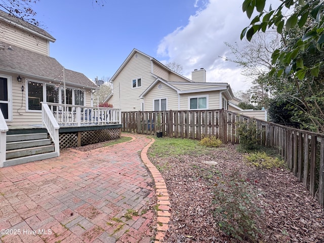 310 Wimbledon Ct, Wilmington, NC 28412 - back of house with a fenced backyard, a patio area, a deck, and a chimney
