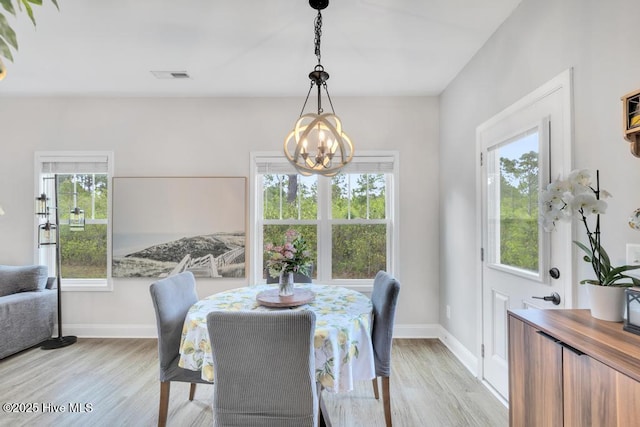 dining room featuring a healthy amount of sunlight, visible vents, and a chandelier