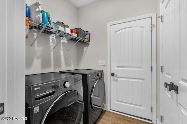 laundry area featuring laundry area, washing machine and dryer, and wood finished floors