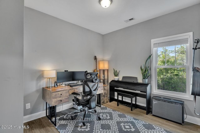 office featuring visible vents, baseboards, and wood finished floors