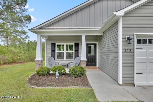 doorway to property with a porch, an attached garage, and a yard