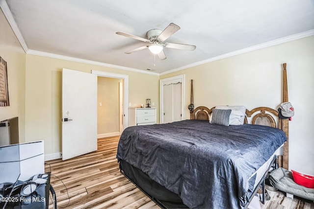 bedroom featuring light wood finished floors, a closet, a ceiling fan, and ornamental molding