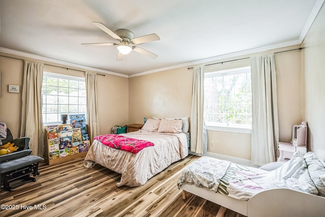 bedroom with a ceiling fan, crown molding, multiple windows, and wood finished floors