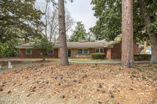 ranch-style home with brick siding and a chimney