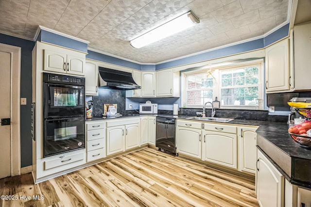 kitchen with black appliances, dark countertops, under cabinet range hood, and a sink