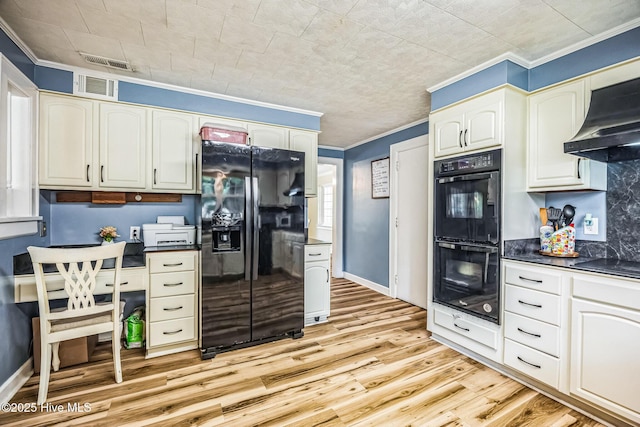 kitchen featuring black appliances, crown molding, dark countertops, and light wood-style floors
