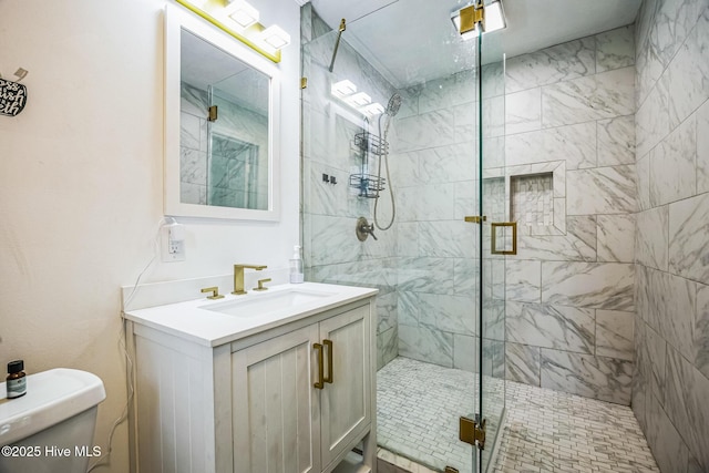 bathroom with vanity, a shower stall, and toilet