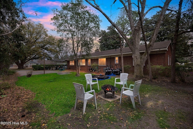 yard at dusk featuring a fire pit