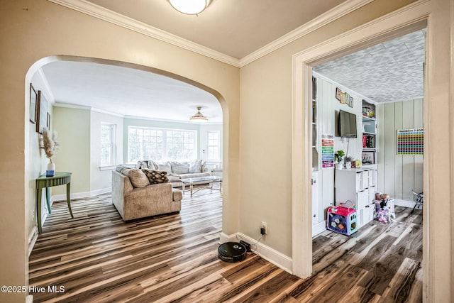 corridor with wood finished floors, arched walkways, and ornamental molding