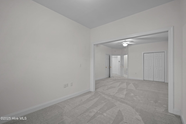 unfurnished room featuring light colored carpet, baseboards, and ceiling fan
