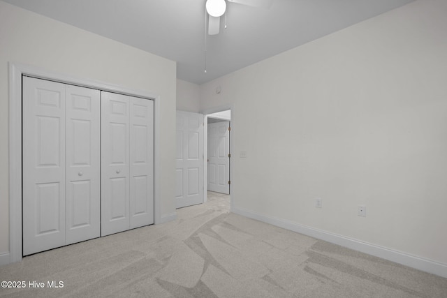 unfurnished bedroom with a closet, a ceiling fan, carpet, and baseboards