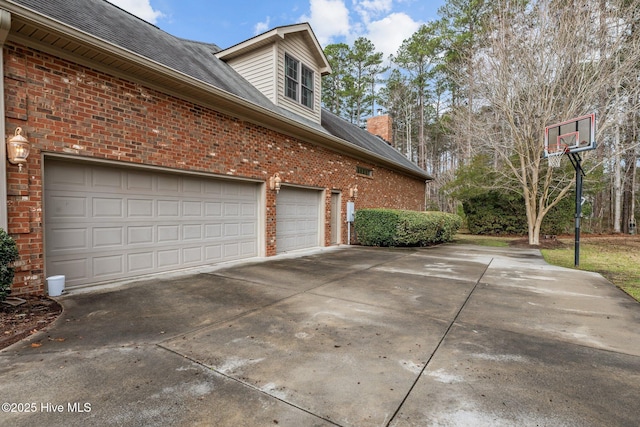 view of property exterior with brick siding, driveway, and a shingled roof
