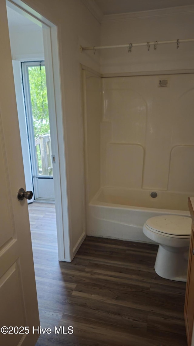 bathroom featuring toilet, ornamental molding, wood finished floors, and shower / bathing tub combination