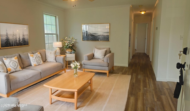 living room featuring a ceiling fan, baseboards, ornamental molding, and wood finished floors