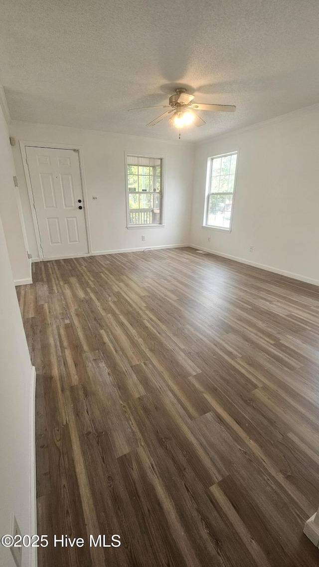 spare room featuring a ceiling fan, baseboards, a textured ceiling, and dark wood-type flooring
