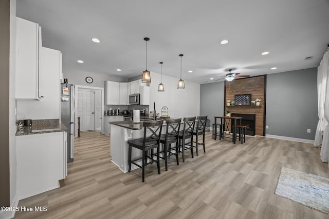 115 Marie Ct, Havelock, NC 28532 - kitchen featuring white cabinets, baseboards, appliances with stainless steel finishes, a breakfast bar, and a ceiling fan