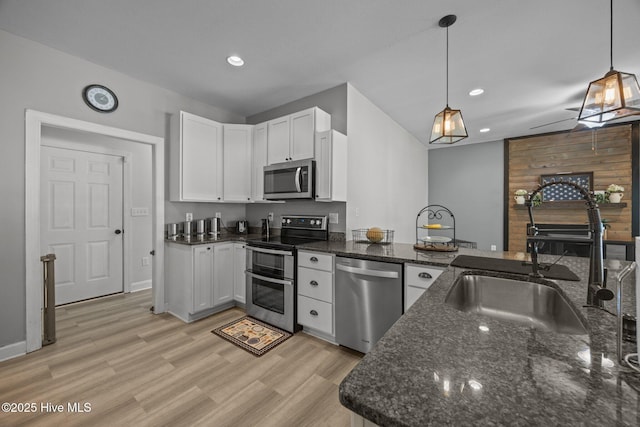 115 Marie Ct, Havelock, NC 28532 - kitchen with dark stone counters, white cabinetry, appliances with stainless steel finishes, a sink, and light wood finished floors