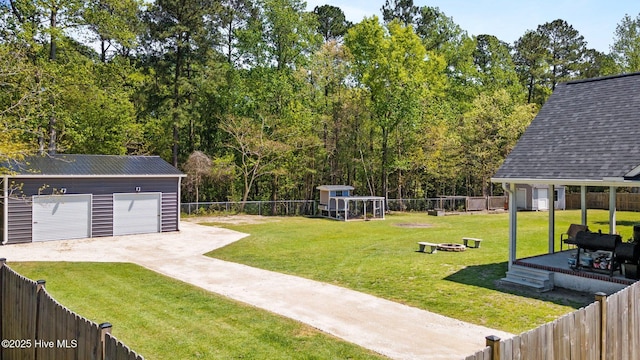 115 Marie Ct, Havelock, NC 28532 - view of yard with a fire pit, a fenced backyard, an outdoor structure, and a detached garage