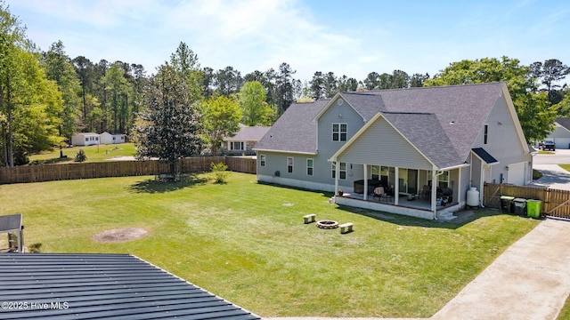 115 Marie Ct, Havelock, NC 28532 - back of property featuring a sunroom, a yard, a fenced backyard, and an outdoor fire pit