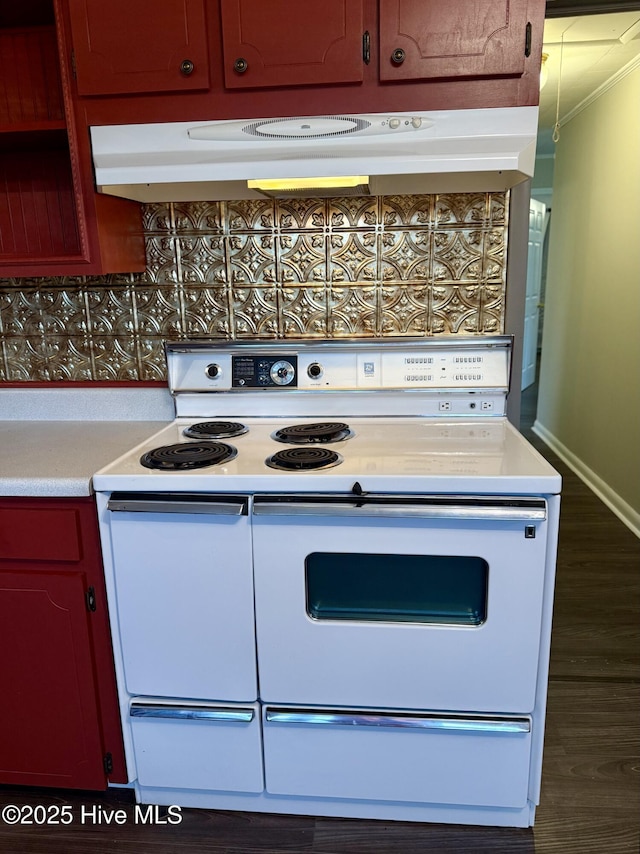 16980 Barnes Dr, Laurinburg, NC 28352 - kitchen featuring white electric stove, light countertops, under cabinet range hood, ornamental molding, and dark wood-style flooring
