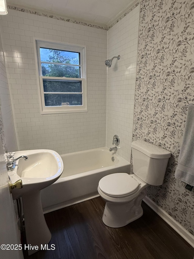 16980 Barnes Dr, Laurinburg, NC 28352 - bathroom with wood finished floors, wallpapered walls, toilet, bathtub / shower combination, and baseboards