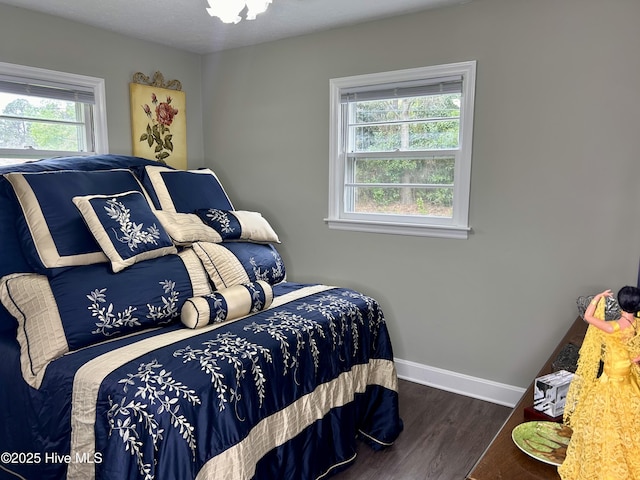 bedroom with baseboards and wood finished floors