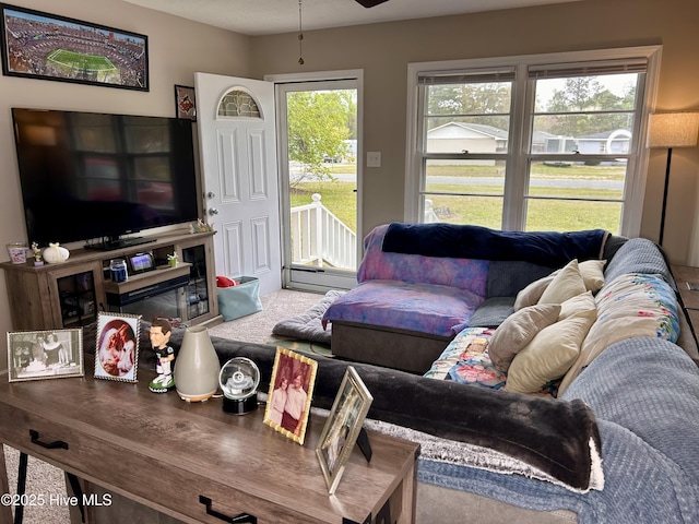 carpeted living room featuring ceiling fan and a baseboard heating unit