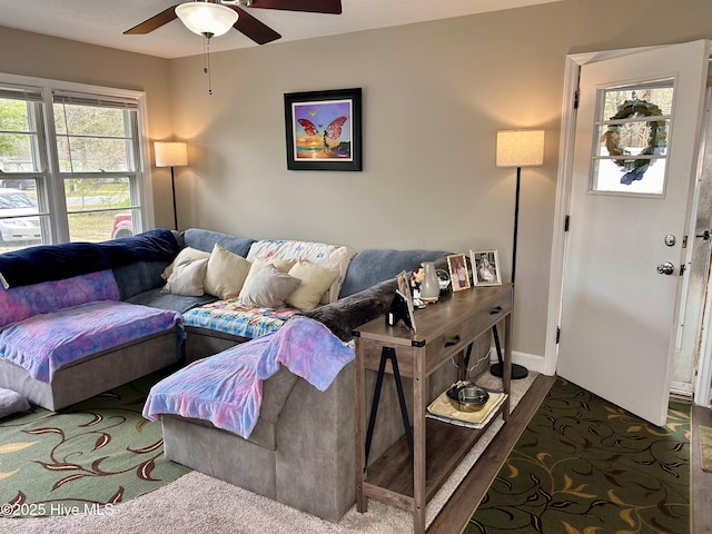 living room with baseboards and a ceiling fan