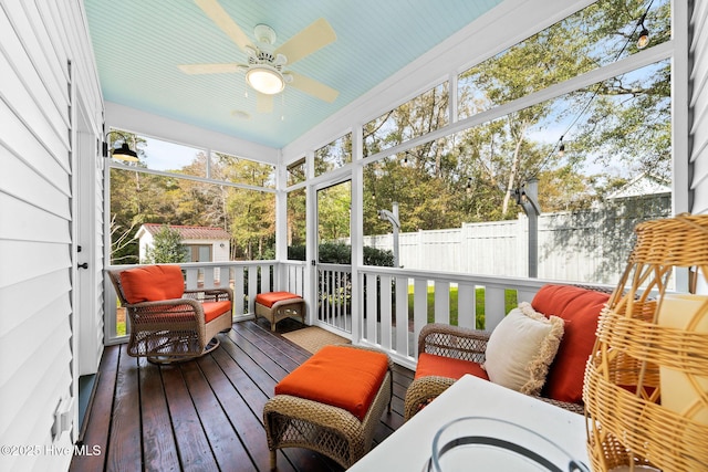 sunroom / solarium featuring a ceiling fan