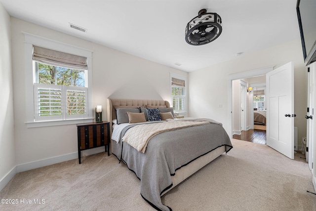 bedroom featuring light carpet, visible vents, and baseboards