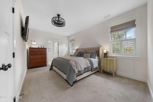 bedroom with visible vents, light carpet, baseboards, and multiple windows