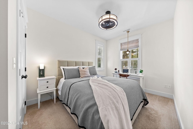 bedroom with baseboards and light colored carpet