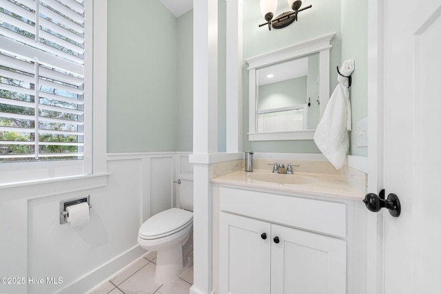 bathroom featuring tile patterned floors, a wainscoted wall, vanity, and toilet