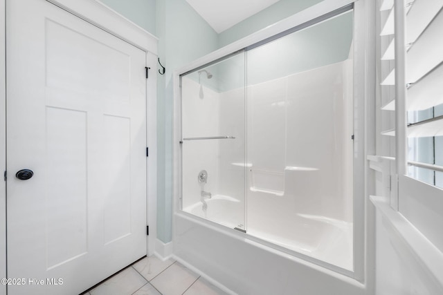 bathroom with baseboards and bath / shower combo with glass door