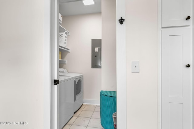 clothes washing area with electric panel, light tile patterned floors, washer and dryer, baseboards, and laundry area