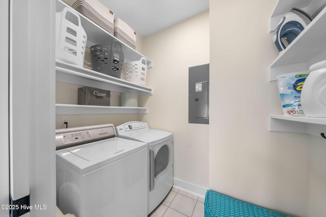 laundry room featuring light tile patterned flooring, electric panel, washing machine and dryer, baseboards, and laundry area
