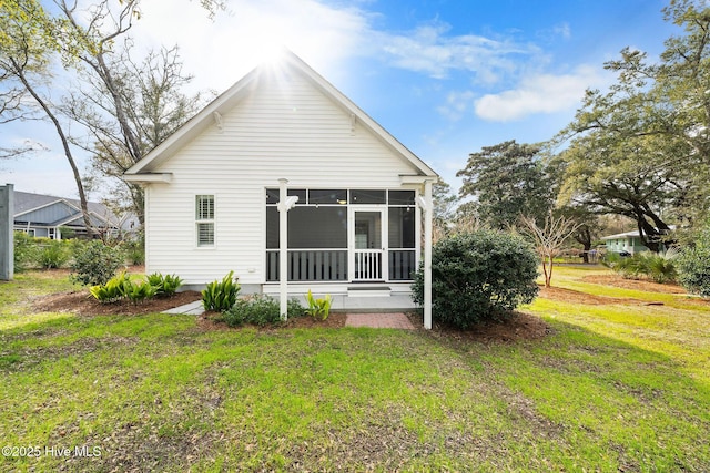rear view of property with a yard and a sunroom