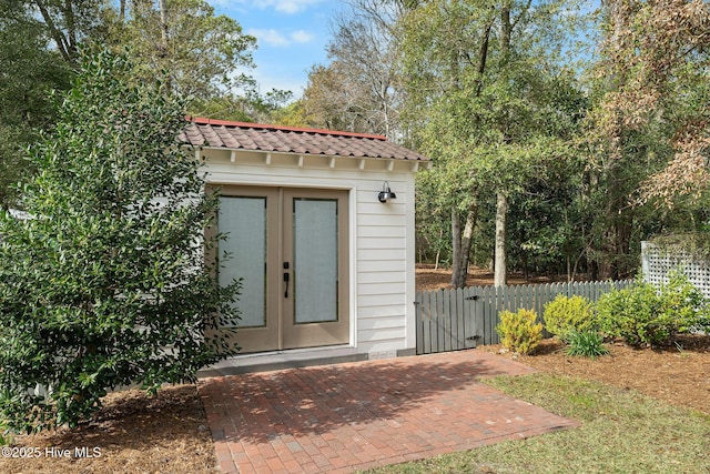 view of outdoor structure with fence and an outbuilding