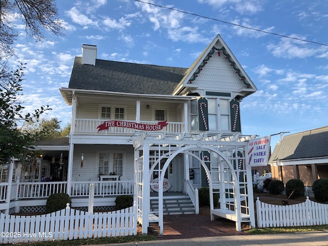 victorian house with stairway, a chimney, a shingled roof, fence, and a porch