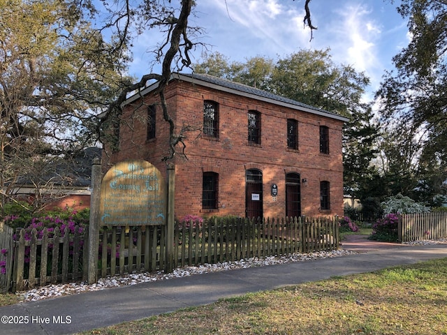 view of front of home featuring brick siding and a fenced front yard
